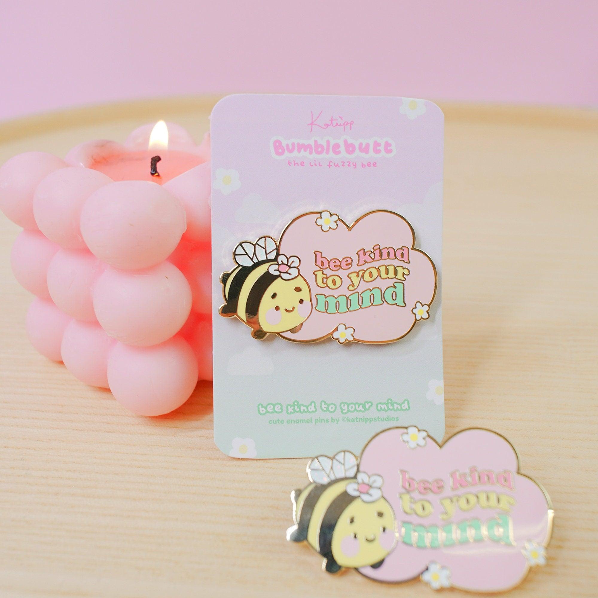 Enamel pin featuring Bumblebutt the bee with text 'Bee Kind to your Mind'