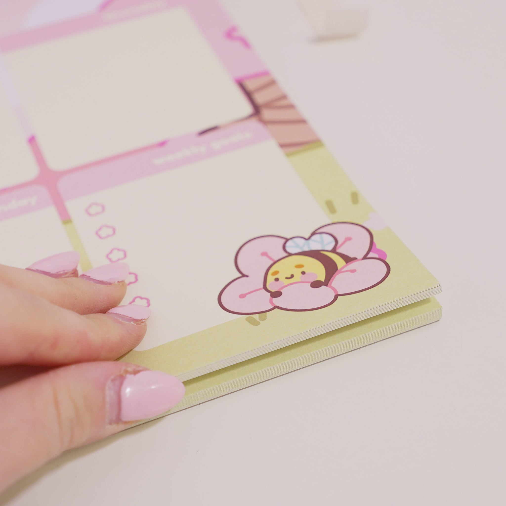 A4 Sakura-inspired desktop planner featuring Bumblebutt the Bumblebee charm and cherry blossom illustrations. Perfect for weekly planning, hand zoomed in
