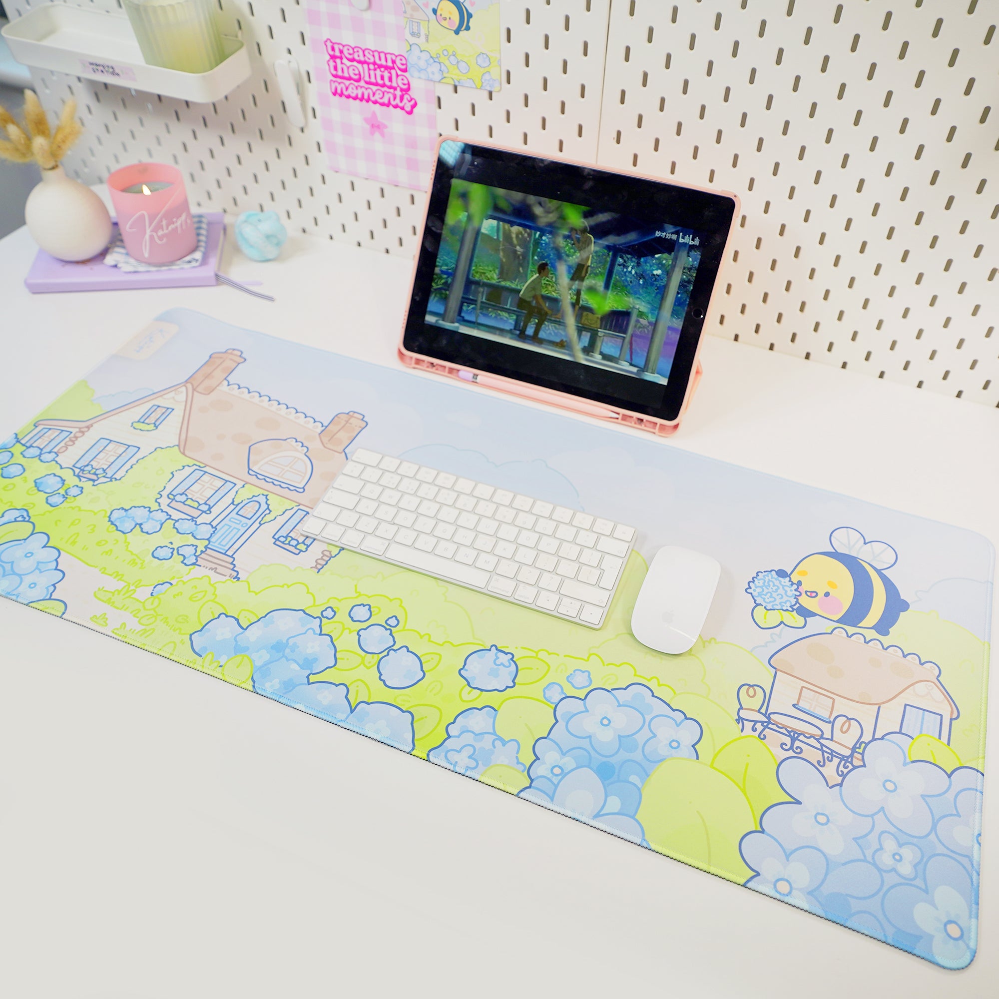 A large gaming mouse pad with a blue hydrangea and bumblebee design, laid out on a desk with a keyboard and mouse.
